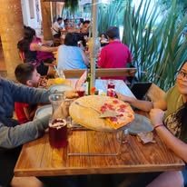 Pizza al centro de una mesa familiar