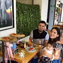 Familia con pizza y bebidas