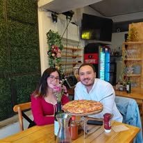 Clientes posando con pizza grande
